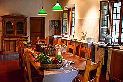 	Küche der Villa beim Kochen mit Blick zu den Fenstern und der Tür zur Speisekammer